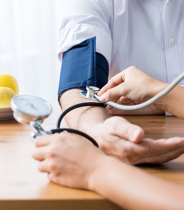 Ein Arzt misst den Blutdruck eines Patienten in einer klinischen Umgebung.